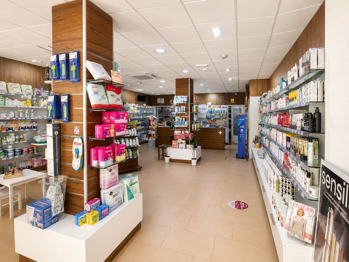 Interior de Farmacia Vázquez Bormujos — pasillo con cuidado infantil y zona de mostrador